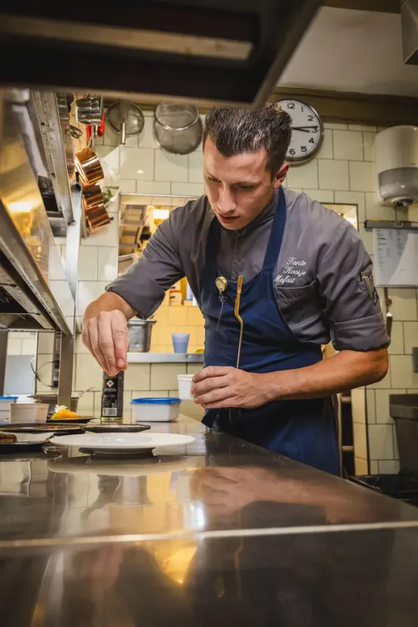 Sous-chef Bas Mafait werkt een bord af in de keuken van Tante Koosje