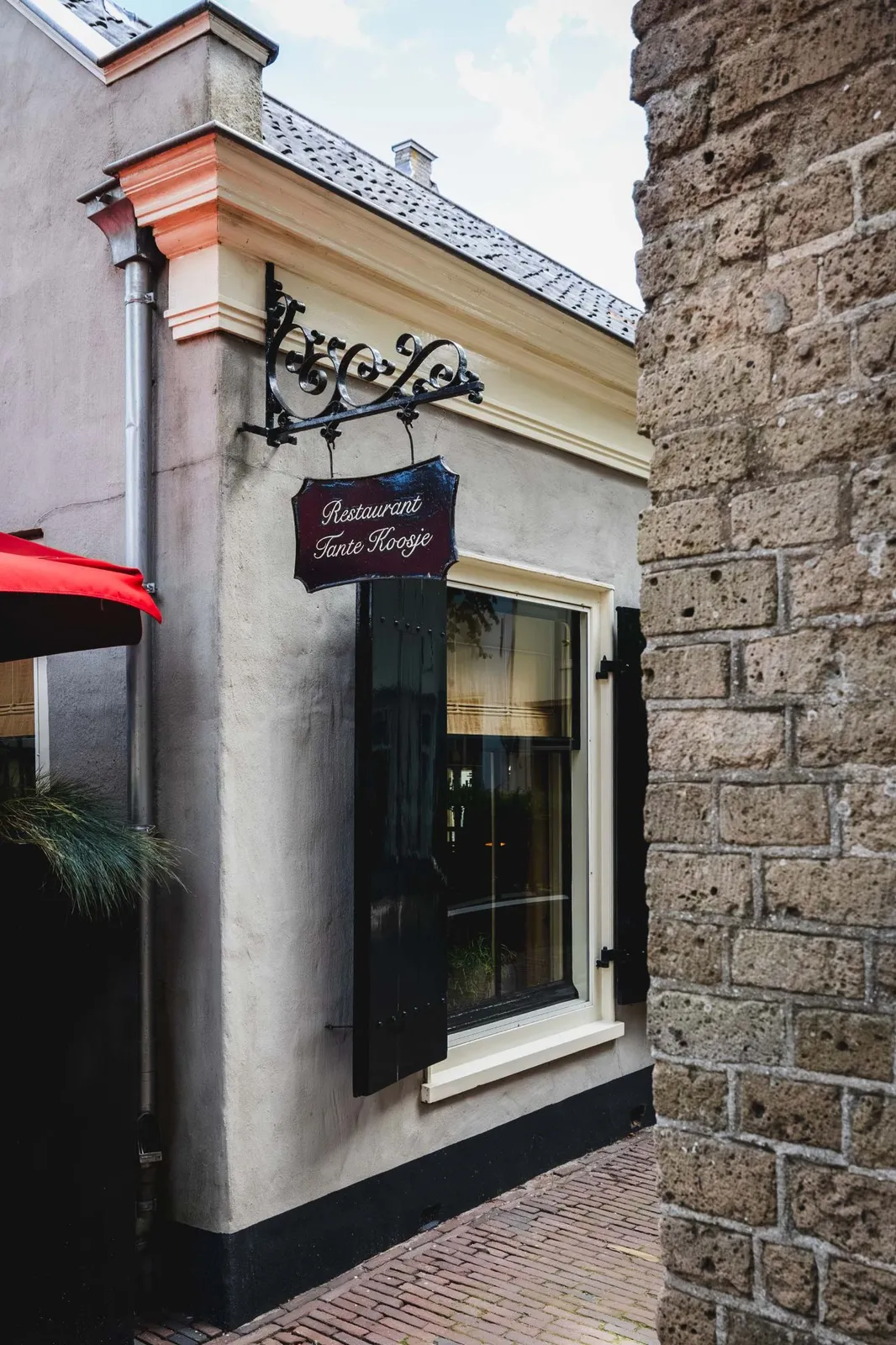 De gevel van Restaurant Tante Koosje met het smeedijzeren uithangbord, aan de Kerkstraat