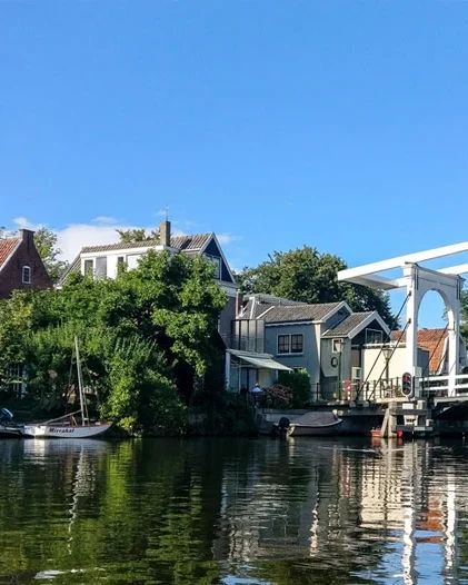 De witte ophaalbrug over de Vecht in Loenen, met de woonhuizen en aangemeerde bootjes langs het water